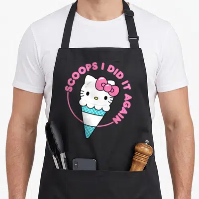 Tablier de cuisine noir avec une boule de glace Hello Kitty et le texte Scoops I Did It Again en rose.