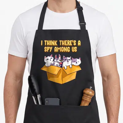 Tablier de cuisine noir avec quatre chats dans une boîte et texte jaune I Think There's A Spy Among Us