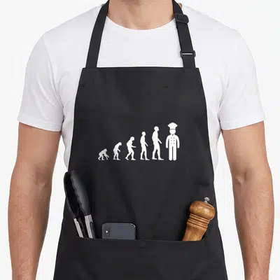 Tablier de cuisine noir avec silhouette évolutive se transformant en cuisinier coiffé d'un toque blanche.