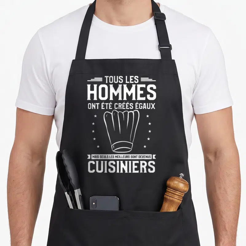 Tablier de cuisine noir avec inscription blanche tous les hommes ont été créés égaux mais seuls les meilleurs sont devenus cuisiniers et une toque.