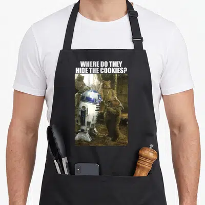 Tablier de cuisine noir avec R2-D2 et des Ewoks posant une question sur le cachet des biscuits