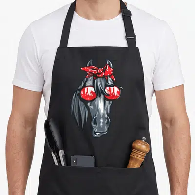 Tablier de cuisine noir avec tête de cheval gris portant des lunettes de soleil rouges et un grand ruban à pois blancs sur la tête.