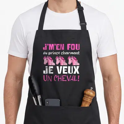 Tablier de cuisine noir avec trois têtes de chevaux roses et le texte J'M'EN FOU du prince charmant JE VEUX UN CHEVAL.