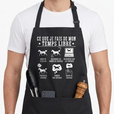 Tablier de cuisine noir avec silhouettes de chevaux et textes blancs illustrant les loisirs équestres.