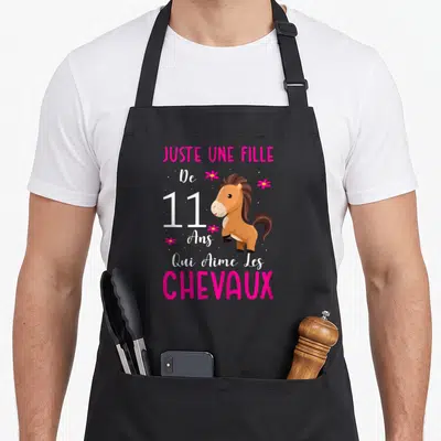 Tablier de cuisine noir avec illustration de poney marron et texte rose blanc Juste une fille de 11 ans qui aime les chevaux.