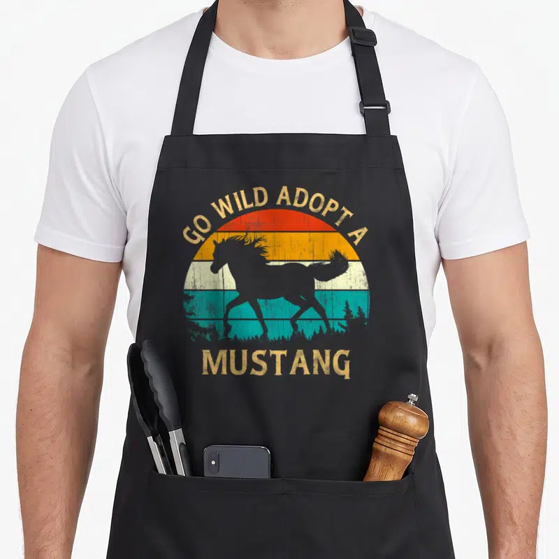 Tablier de cuisine noir avec silhouette de mustang et texte Go Wild Adopt a Mustang sur fond de soleil rétro