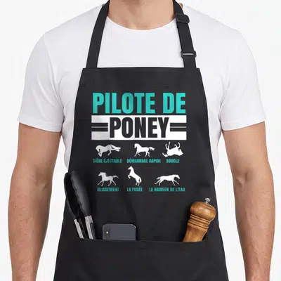 Tablier de cuisine noir avec inscription Pilote de Poney et silhouettes de poneys en mouvement blanc et turquoise.