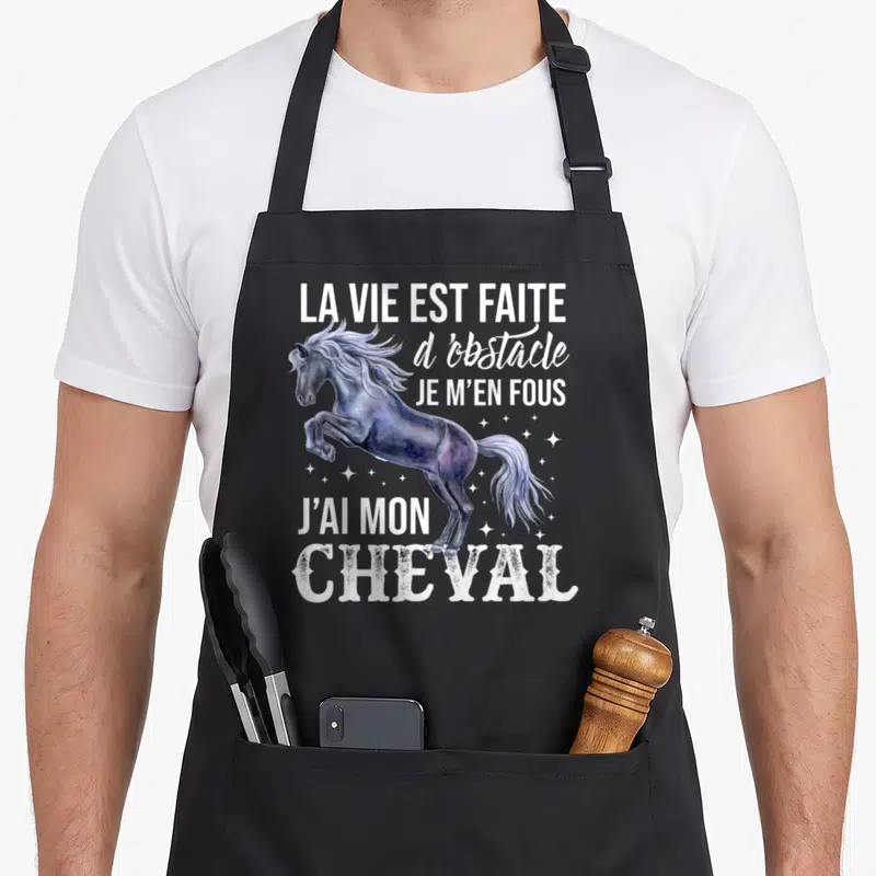 Tablier de cuisine noir avec illustration d'un cheval sautant et texte blanc humoristique sur fond uni.