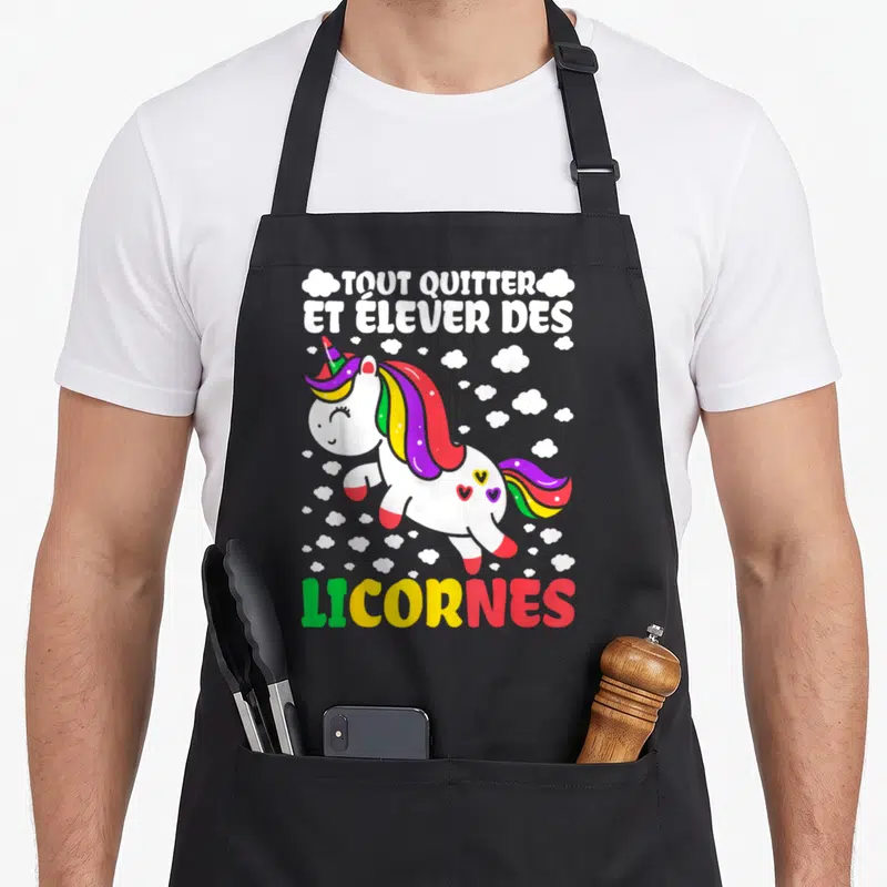 Tablier de cuisine noir avec une licorne arc-en-ciel et le texte tout quitter et élever des licornes en lettres colorées.
