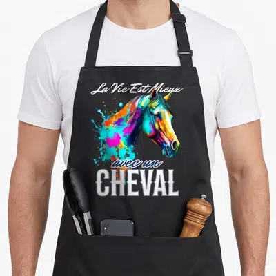Tablier de cuisine noir avec une illustration multicolore de tête de cheval et le texte La Vie Est Mieux avec un CHEVAL en blanc.