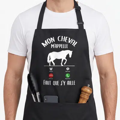 Tablier de cuisine noir avec silhouette de cheval et texte Mon Cheval m'appelle Faut que j'y aille sur fond blanc.