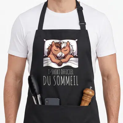 Tablier de cuisine noir avec deux poneys dormeurs et le texte « Officiel du Sommeil » imprimé en blanc.