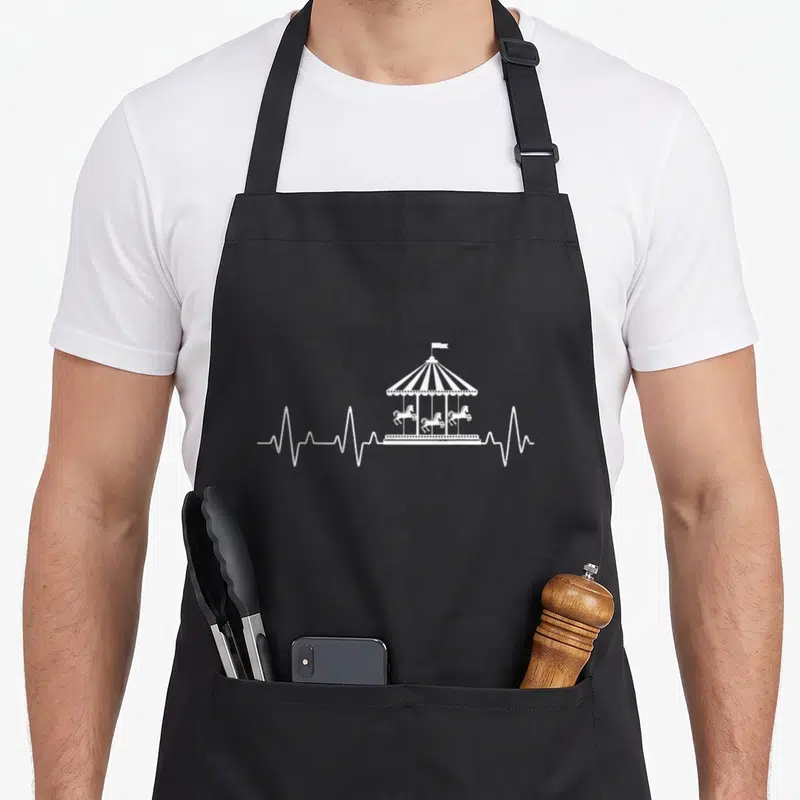 Tablier de cuisine noir avec illustration blanche d'un carrousel de chevaux surmonté d'une ligne de vie.