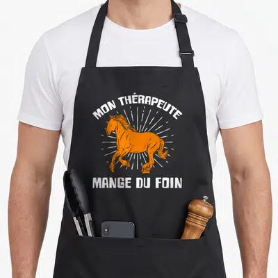 Tablier de cuisine noir avec illustration d'un cheval orange et texte blanc Mon thérapeute mange du foin