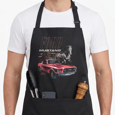 Tablier de cuisine noir avec une Ford Mustang rouge et un cheval en arrière-plan