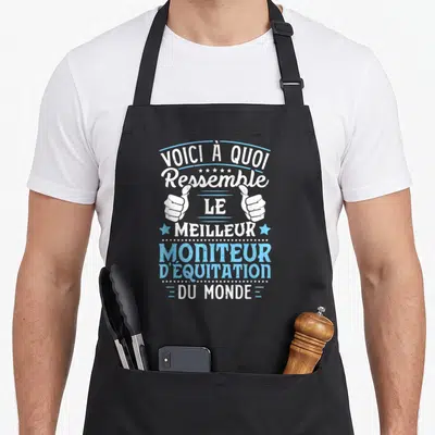 Tablier de cuisine noir avec inscription blanche et bleue Voici à quoi ressemble le meilleur moniteur d'équitation du monde surmontée de deux pouces levés.