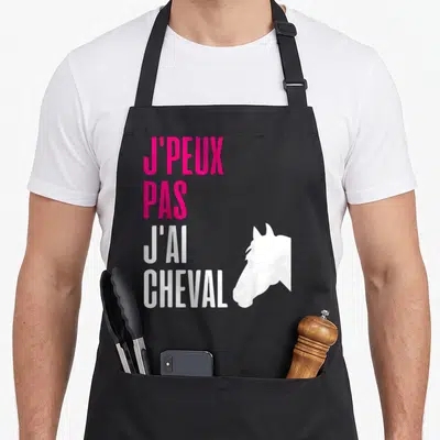 Tablier de cuisine noir avec texte J'peux pas j'ai cheval et silhouette de tête de cheval blanche sur fond gris.