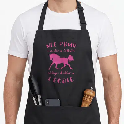 Tablier de cuisine noir avec silhouette de cheval rose et texte Née Pour Monter A Cheval obligée d'aller a l'école