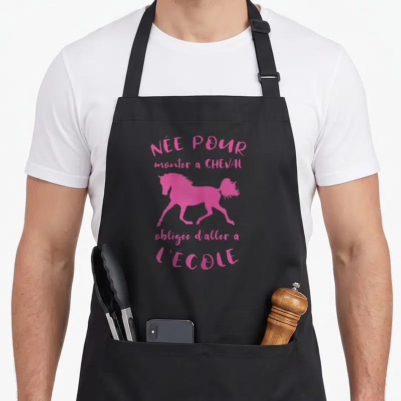 Tablier de cuisine noir avec silhouette de cheval rose et texte Née Pour Monter A Cheval obligée d'aller a l'école