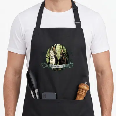 Tablier de cuisine noir avec illustration circulaire de deux cavaliers et une banderole Outlander.