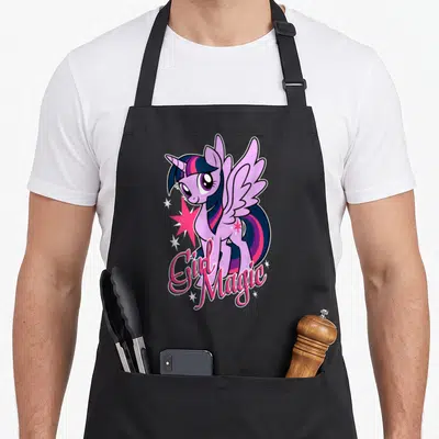 Tablier de cuisine noir avec illustration de licorne rose et texte Girl Magic entouré d'étoiles.