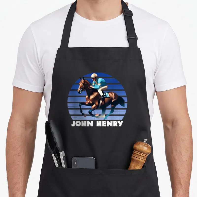 Tablier de cuisine noir avec illustration d'un jockey chevauchant John Henry sur fond bleu rayé et texte blanc.