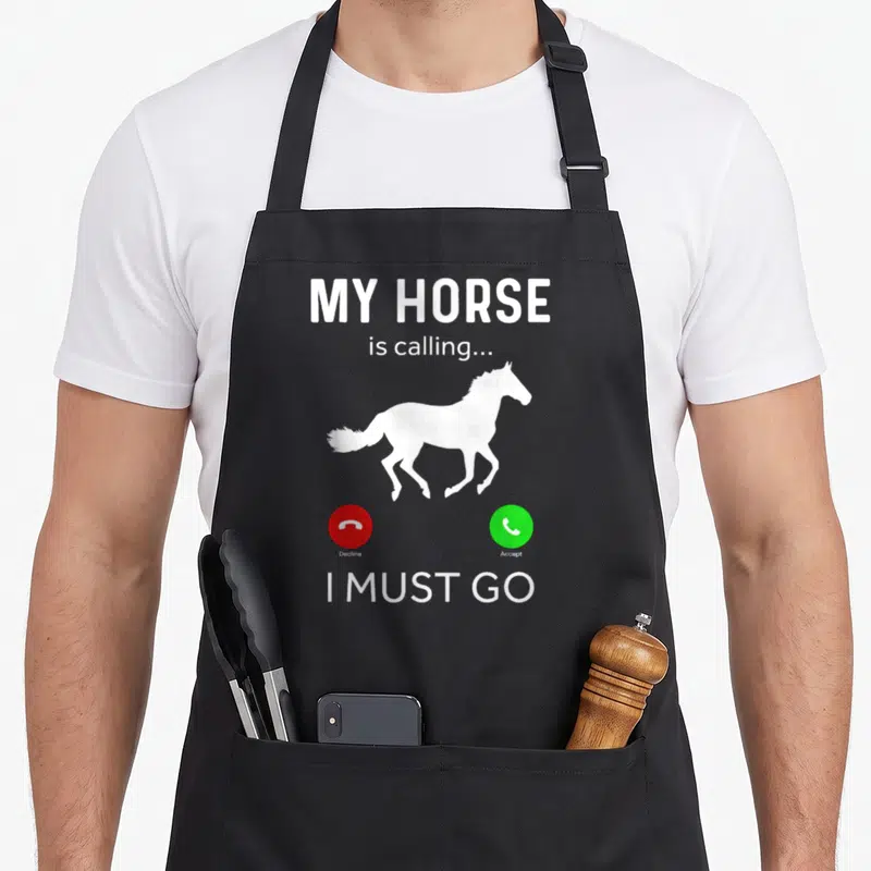 Tablier de cuisine noir avec silhouette de cheval blanc et texte My Horse is calling I must go