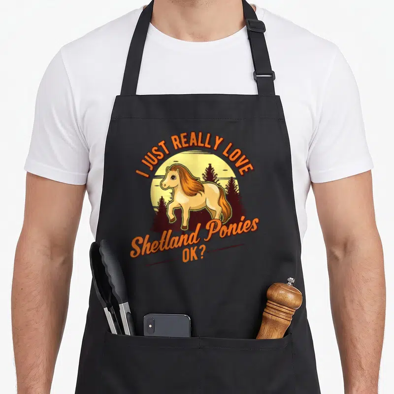 Tablier de cuisine noir avec illustration d'un poney Shetland devant un soleil et des arbres, entouré du texte I JUST REALLY LOVE Shetland Ponies OK ?