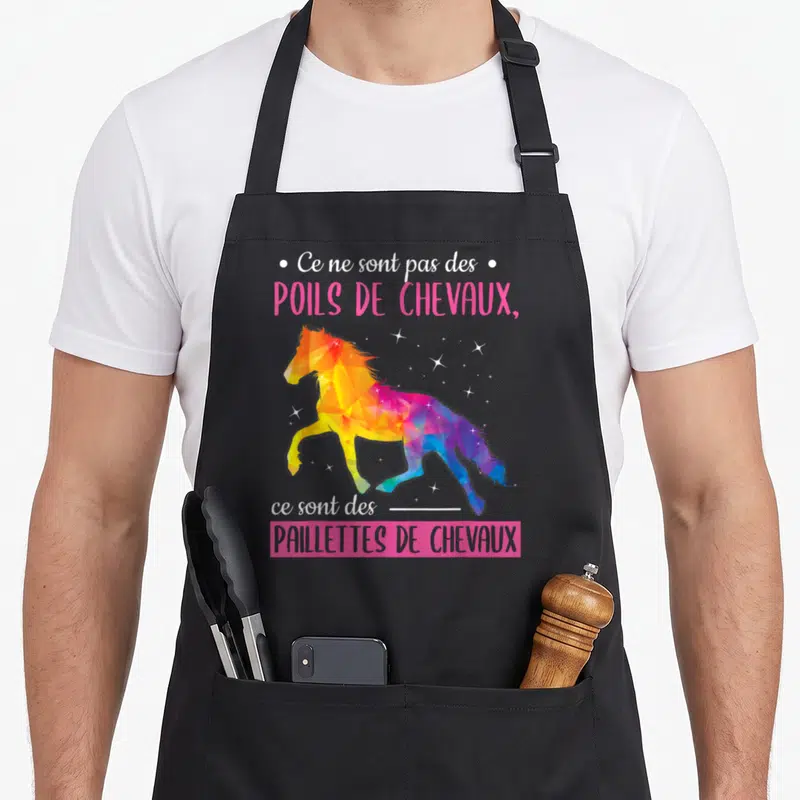 Tablier de cuisine noir avec un cheval géométrique coloré et le texte Ce ne sont pas des poils de chevaux, ce sont des paillettes de chevaux.