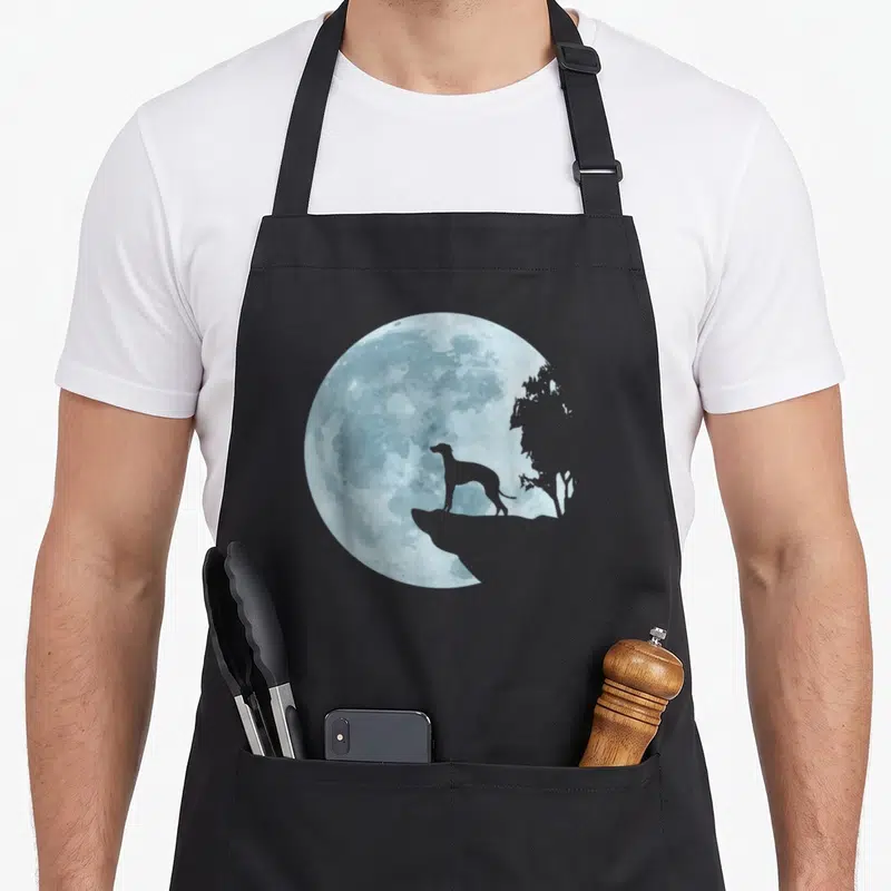 Tablier de cuisine noir avec un lévrier en silhouette devant une lune bleue texturée.