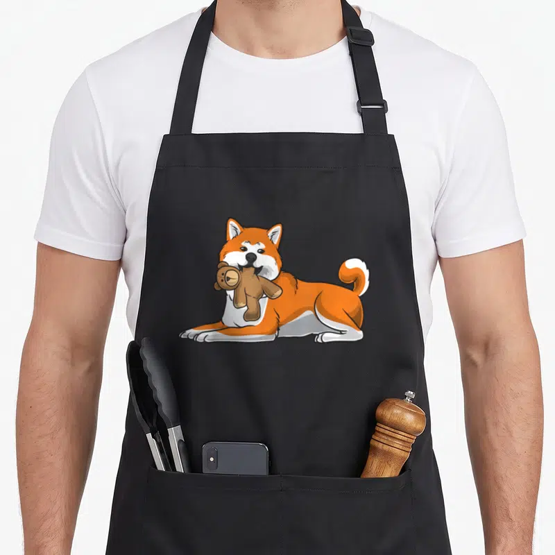 Tablier de cuisine noir avec illustration d'un chien Akita Inu portant une peluche d'ours en tissu.