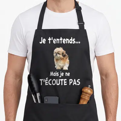 Tablier de cuisine noir avec un chien Shih tzu et le texte Je t'entends mais je ne t'écoute pas en blanc.