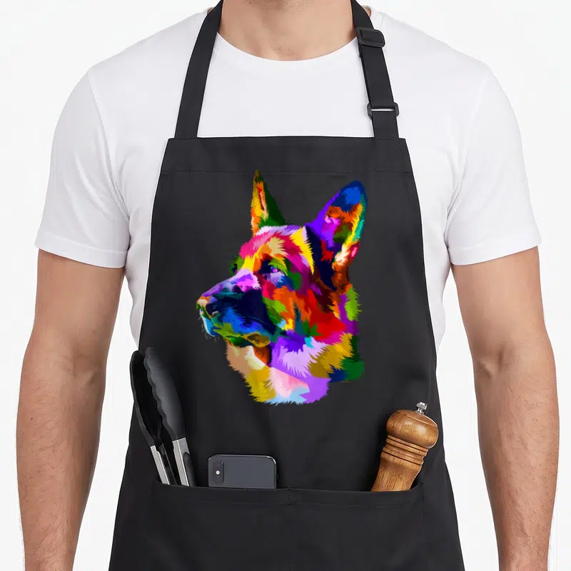 Tablier de cuisine noir avec portrait artistique d'un berger allemand aux multiples couleurs vives.