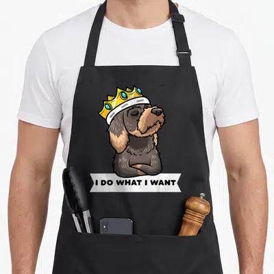 Tablier de cuisine noir avec illustration d'un teckel à poil dur portant une couronne et le texte I DO WHAT I WANT.