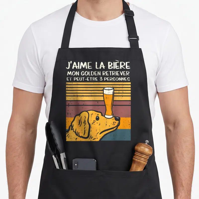Tablier de cuisine noir avec illustration d'un Golden Retriever tenant une bière sur le nez et texte humoristique en haut.