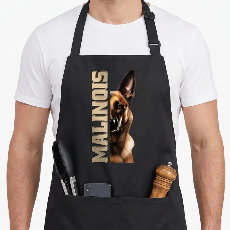 Tablier de cuisine noir avec illustration réaliste d'un Malinois et le mot MALINOIS écrit verticalement en lettres capitales beige.