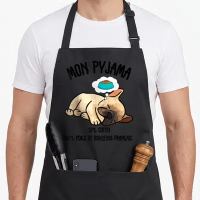 Tablier de cuisine noir avec illustration d'un bouledogue français dormant et une pensée sur un bol de nourriture.