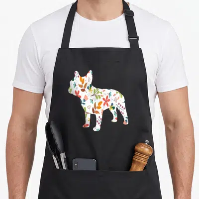 Tablier de cuisine noir avec silhouette de bouledogue français décorée de fleurs et de feuilles multicolores dans un style botanical.