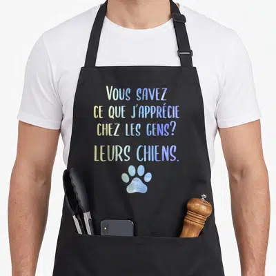 Tablier de cuisine noir avec texte coloré et une empreinte de patte bleue en bas du motif imprimé.