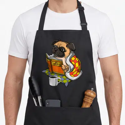 Tablier de cuisine noir avec illustration d'un carlin lisant un livre sous une couverture à carreaux.