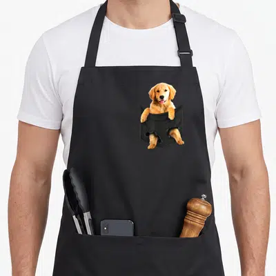 Tablier de cuisine noir avec un chiot Golden Retriever sortant d'une poche imprimée en 3D.