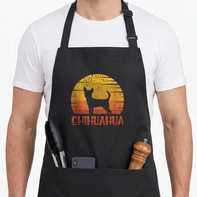 Tablier de cuisine noir avec silhouette chihuahua et texte CHIHUAHUA sur fond soleil rétro orange et jaune.