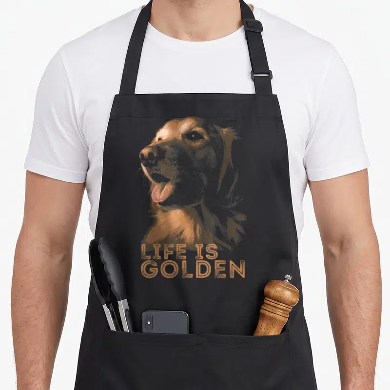 Tablier de cuisine noir avec illustration d'un Golden Retriever et le texte LIFE IS GOLDEN en orange.