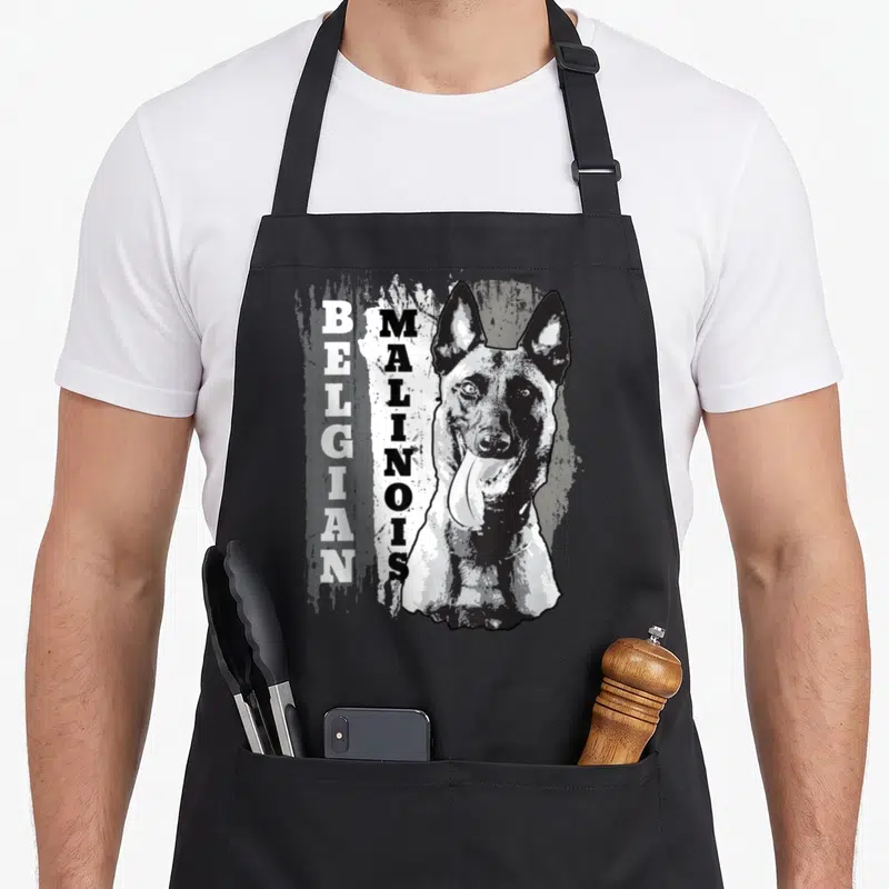 Tablier de cuisine noir avec portrait stylisé d'un chien Malinois belge et texte vertical en noir et blanc.