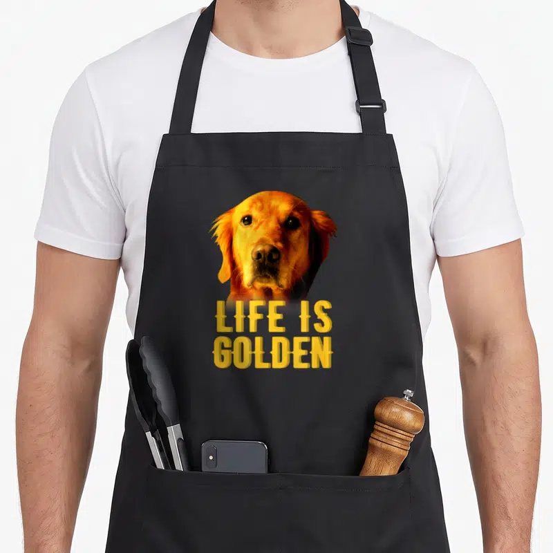 Tablier de cuisine noir avec portrait de chien doré et texte Life is Golden en lettres capitales jaunes.