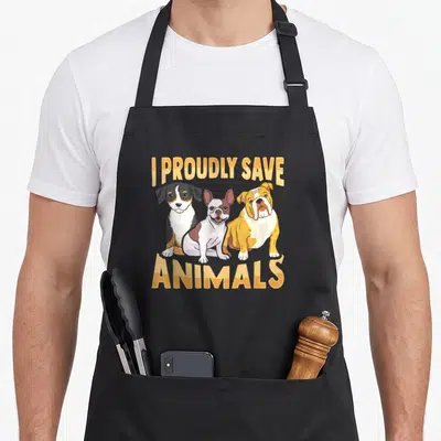 Tablier de cuisine noir avec trois chiens dessinés et le texte I proudly save animals en orange
