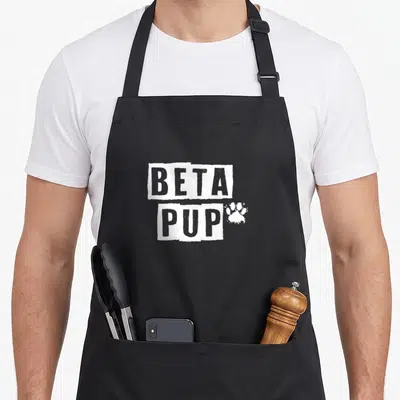 Tablier de cuisine noir avec linscription Beta Pup et une patte danimal blanche sur le devant.