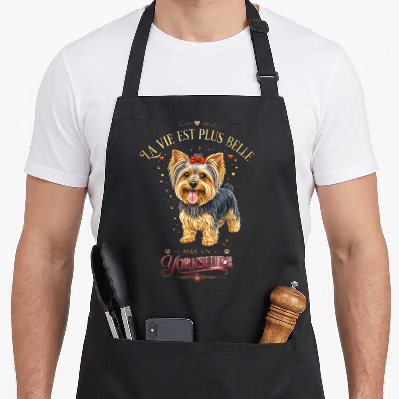 Tablier de cuisine noir avec illustration d'un chien Yorkshire au ruban rouge et texte doré La vie est plus belle avec un Yorkshire