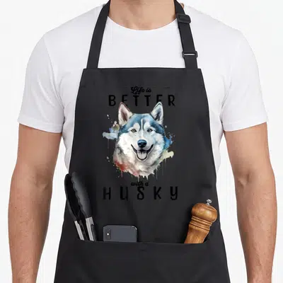 Tablier de cuisine noir avec portrait aquarelle coloré de husky souriant et texte Life is BETTER with a HUSKY en typographie noire.