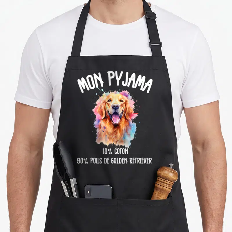 Tablier de cuisine noir avec illustration colorée d'un Golden Retriever et texte blanc humoristique sur fond uni.